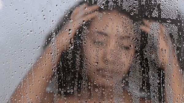 Applying The Detox pre-poo scalp treatment before shampooing in the shower