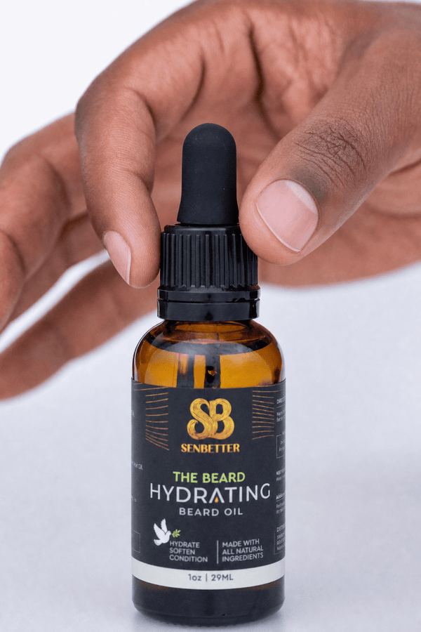Hand holding The Beard botanical beard oil bottle with dropper