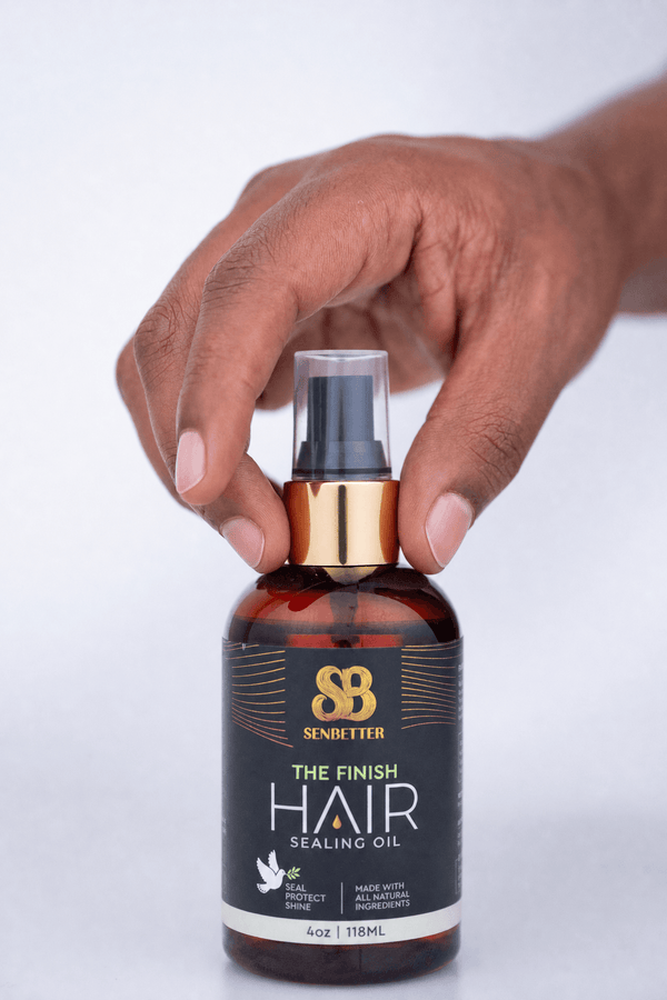 Hand holding The Finish hair sealing oil bottle