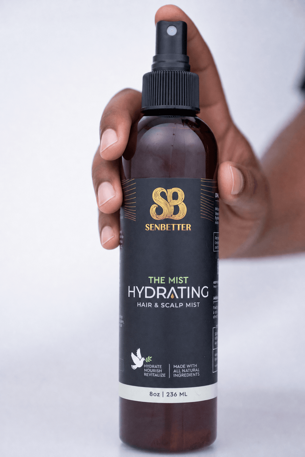 Hand holding Senbetter The Mist hydrating hair spray bottle